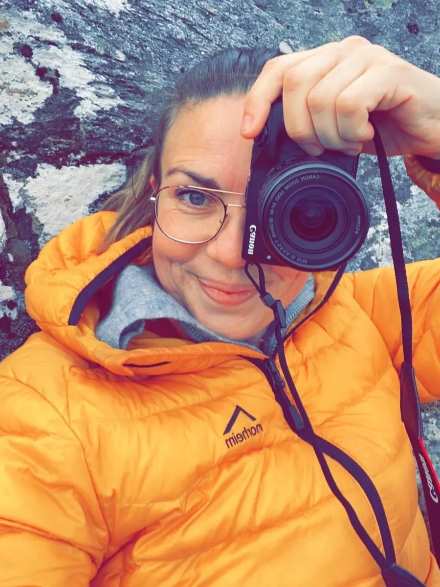 Beate Stavdal Riise i gul jakke med kameraet foran ansiktet